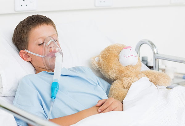 Тяжелобольной ребенок в кислородной маске