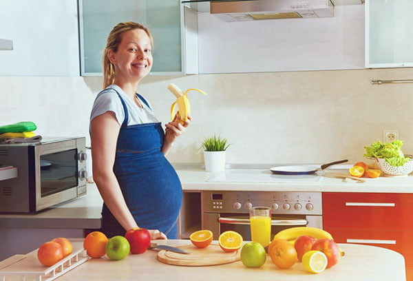 Беременная женщина ест банан