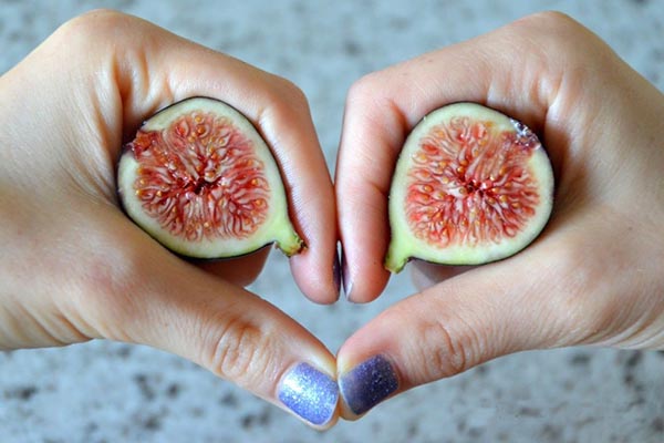 Женщина держит половинки инжира
