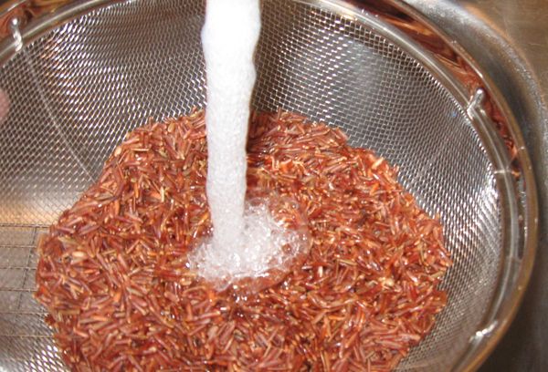 промывание риса с помощью сита под проточной водой