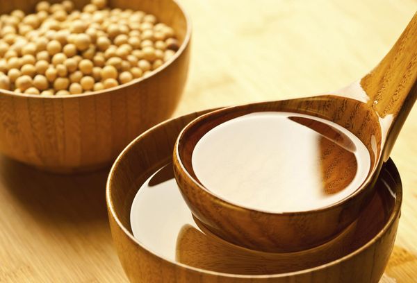 соя и масло из сои на деревянной ложке
