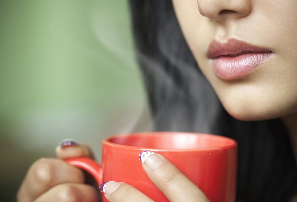 Женщина пьет горячую воду