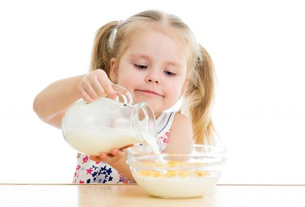 девочка заливает молоком хлопья