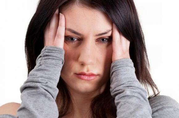Женщина держится за голову