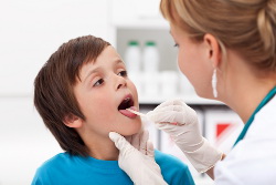 Say aaah - little boy at the physician checking his throat