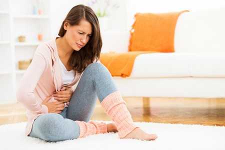 Женщина держится за живот