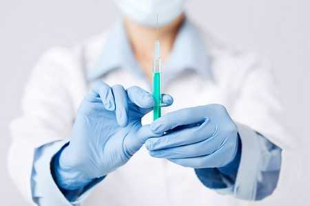 Врач держит шприц Врач держит шприц