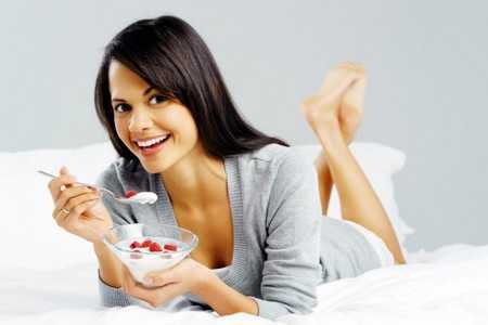 Женщина кушает творог с фруктами