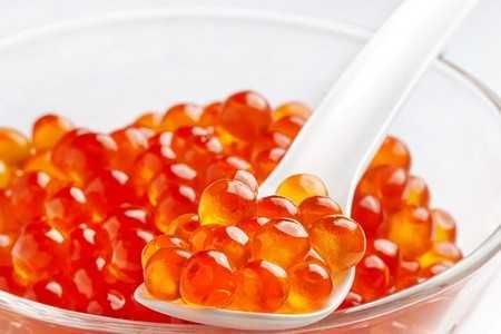 Тарелка и ложка с красной икрой