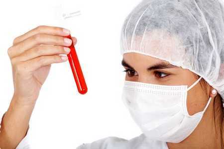 Врач держит пробирку с кровью