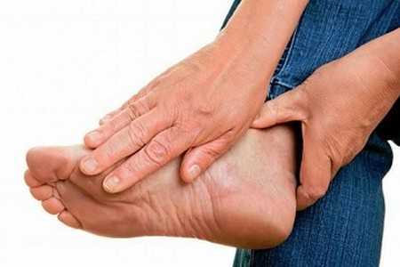 Мужчина держится за ногу Мужчина держится за ногу