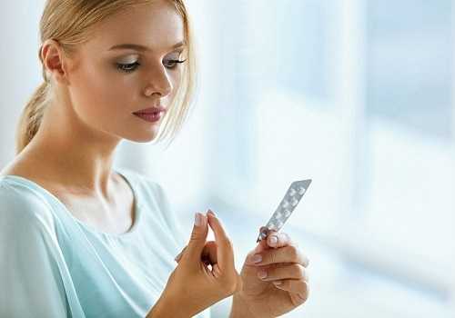 Девушка держит таблетки