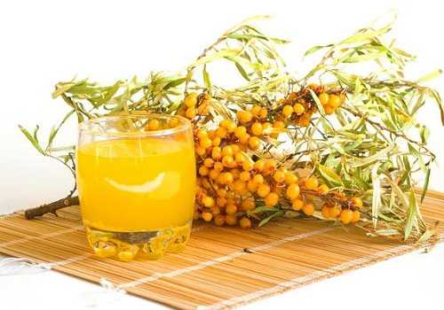 Стакан с соком из облепихи и ветки облепихи