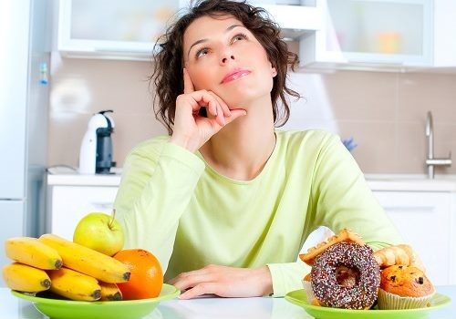 Девушка и тарелки с фруктами и сдобой