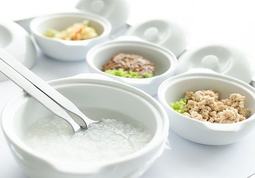 Тарелки с кашей, котлетой и овощами