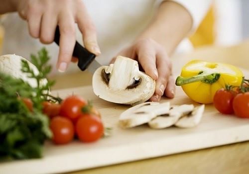 Женщина режет грибы